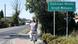 A  man rides a bike passed a signpost for the town of Dobrzeń Wielki 